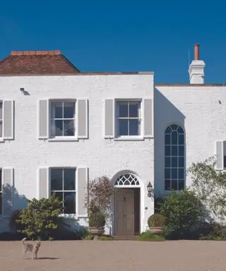 Brick house painted white with terracotta roof