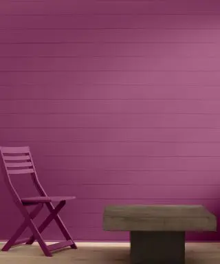 purple brick wall with outdoor table and chair