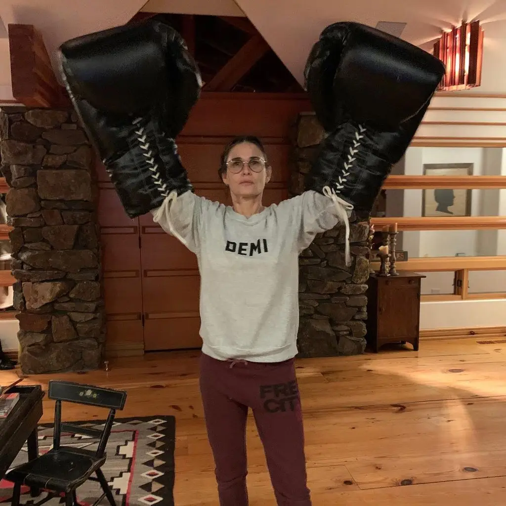 Demi moore holding up giant boxing gloves at home