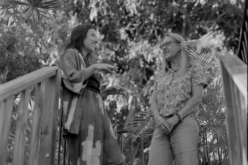 Two woman talking at top of stairs