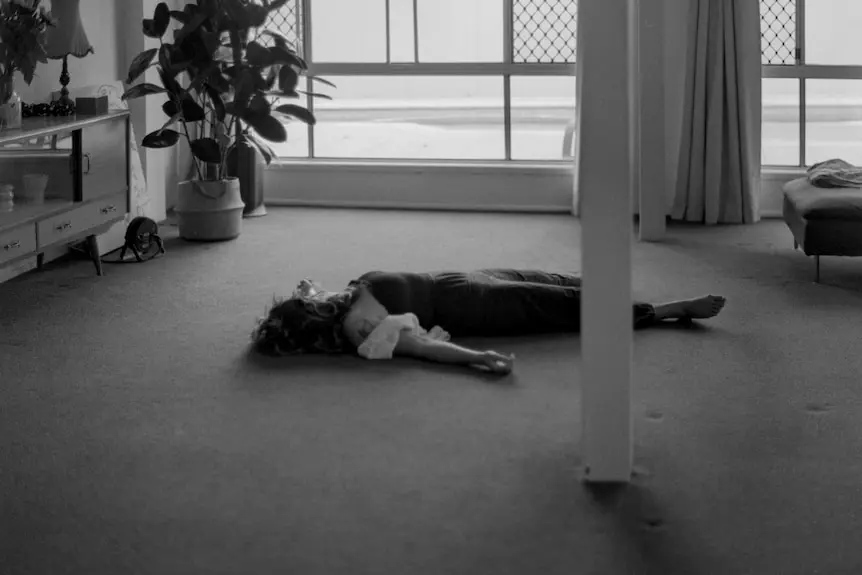 Woman lies on the carpet inside