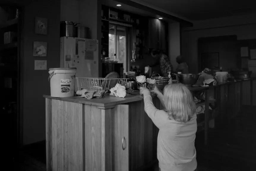 Girl picks up flowers on sink