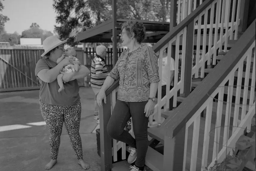 Woman kissing a baby near stairs