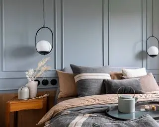 bedroom with light blue panelled wall and modern pendant lights