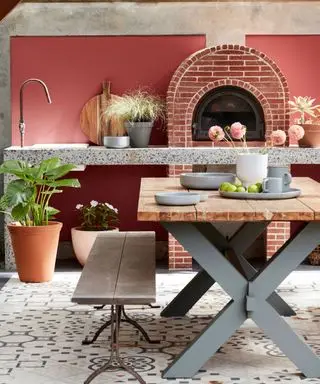 Outdoor kitchen with dining table, outdoor sink, pizza oven and grill