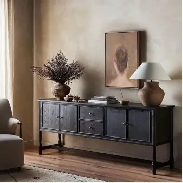 a black cabinet with a lamp and a plant on top a black cabinet with a lamp and a plant on top