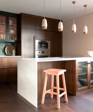 Wooden kitchen with a marble waterfall countertop