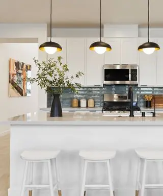 A blue and white kitchen with a large island designed by Bobby Berk