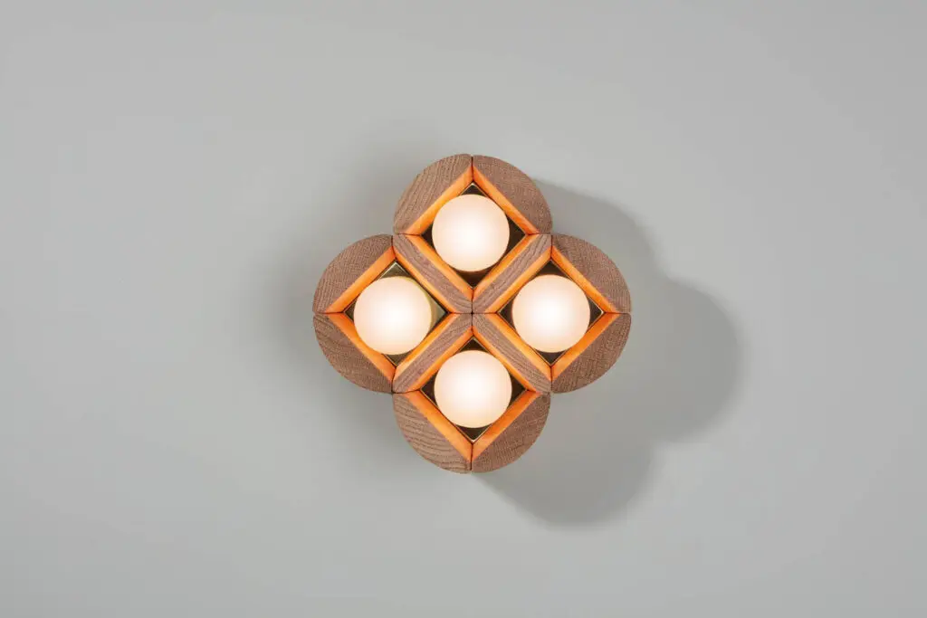 a wall sconce with four quadrants and circular lights inside