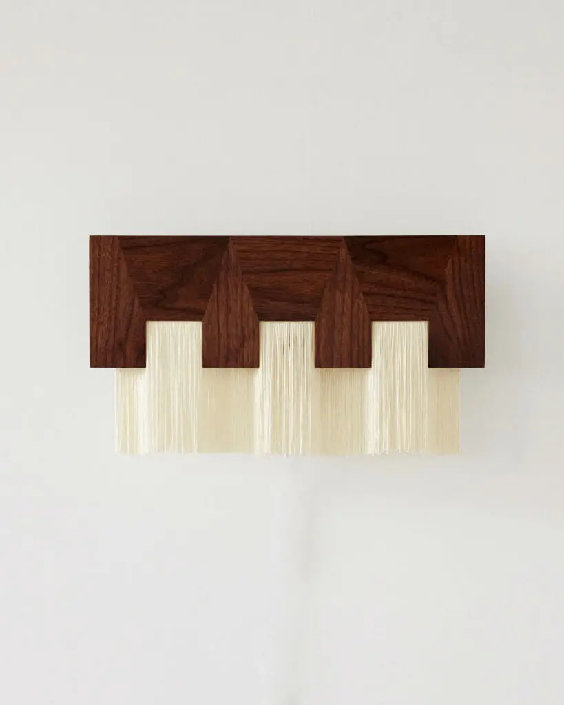 a brown rectangular wall sconce with three white lights