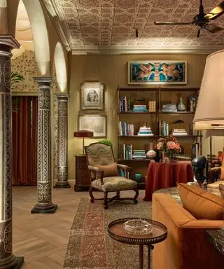 sitting room with pillars and chair and book shelf