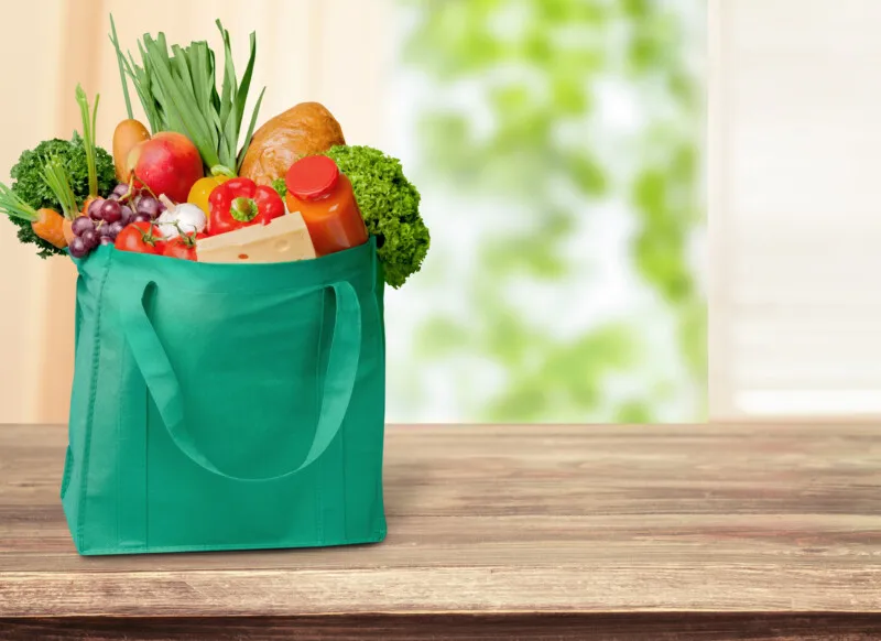 reusable grocery bag full of veggies, for article on how to reduce household waste