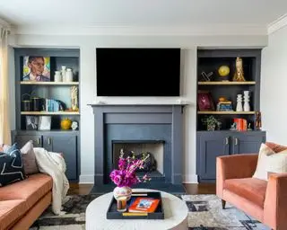 living room with gray fireplace and cupboards, orange sofa and armchair