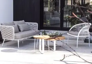 Anjou outdoor sofa with two tables in the middle of the patio