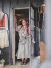 Woman standing in doorway wearing a bandana