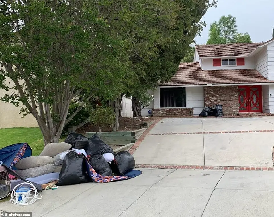 Several black garbage bags that were also dumped during the move can be seen littering the driveway of the home