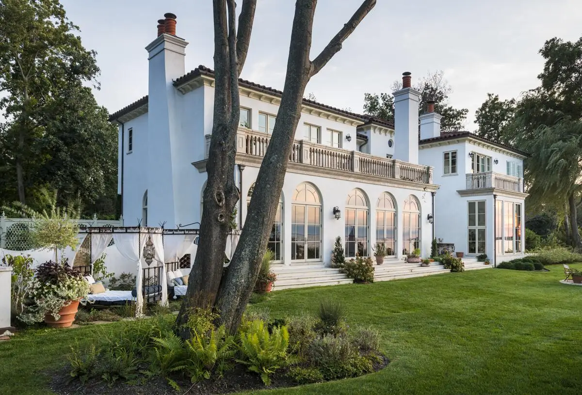 A remodeled luxury house on Long Island has a new stucco exterior and clay-tile roof.