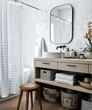 Neutral bathroom with a blue and green stripe shower curtain