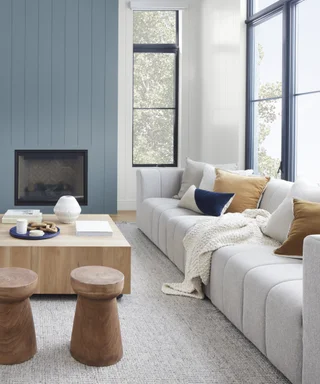 A living room with a white couch and a blue accent wall.