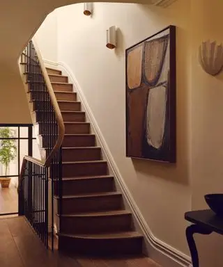 Warm neutral entryway with wooden staircase