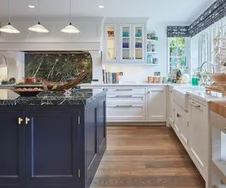 White kitchen with black marble countertops on the kitchen island