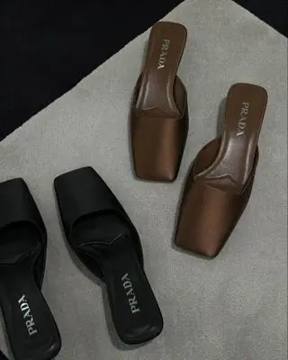 Prada satin mules in black and brown.