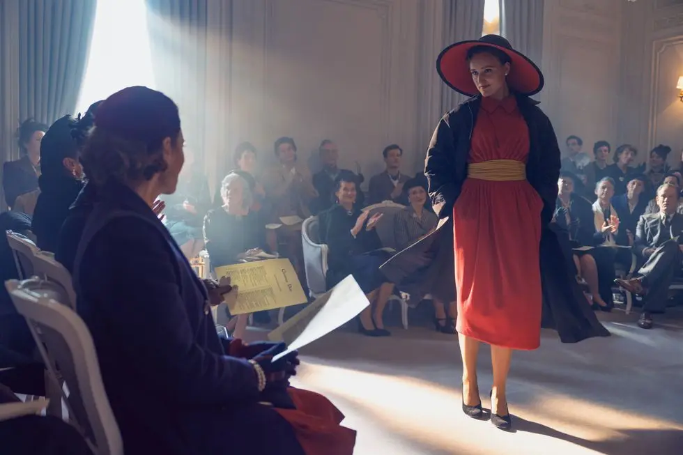 a person in a red dress standing in front of a group of people