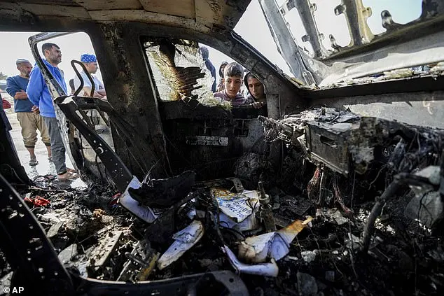 Palestinians inspect a vehicle with the logo of the World Central Kitchen that was wrecked by an Israeli airstrike in Deir al Balah, Gaza Strip, pictured yesterday