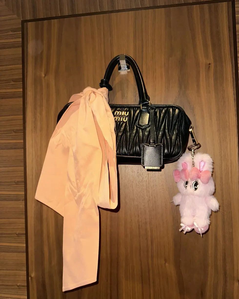 a pink stuffed animal next to a bag and a pink stuffed animal