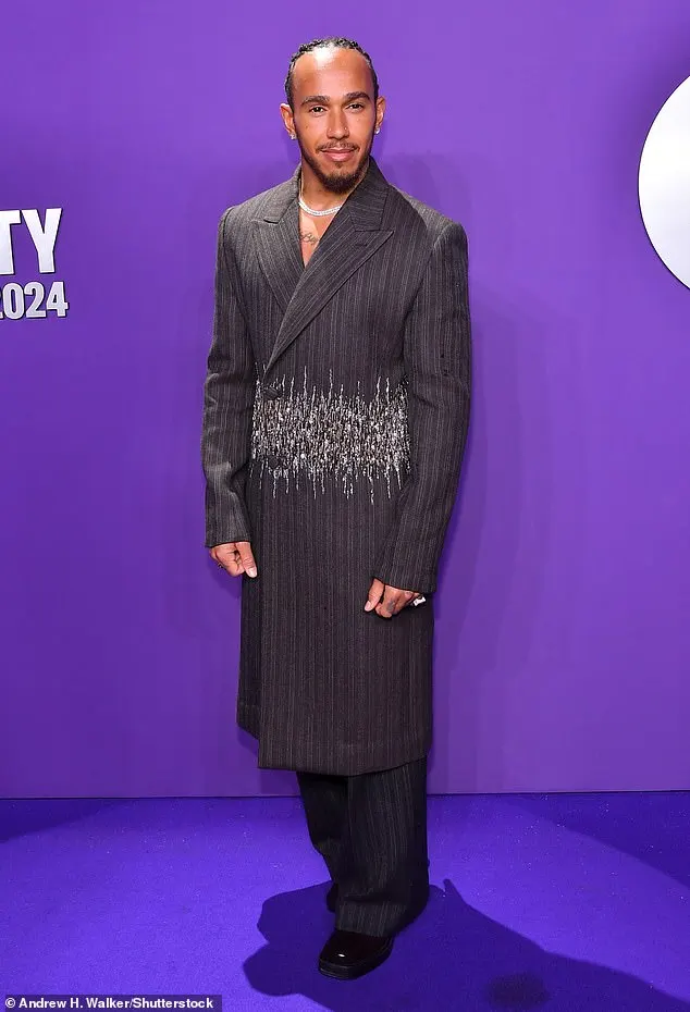 Lewis Hamilton showed off his unique sense of style as he went shirtless underneath a long pinstripe Dior coat at the GQ Global Creativity Awards in New York on Thursday