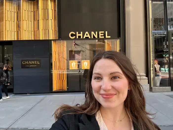 A woman takes a selfie in front of a store with 