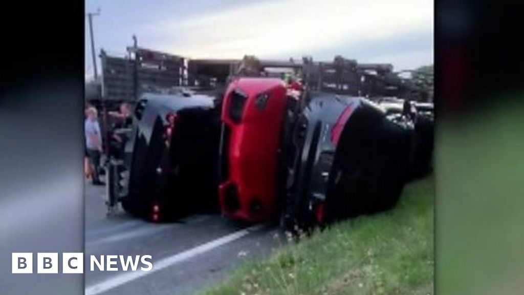 Transporter carrying luxury sports cars overturns