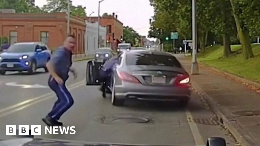 Moment police officer dragged away by escaping car