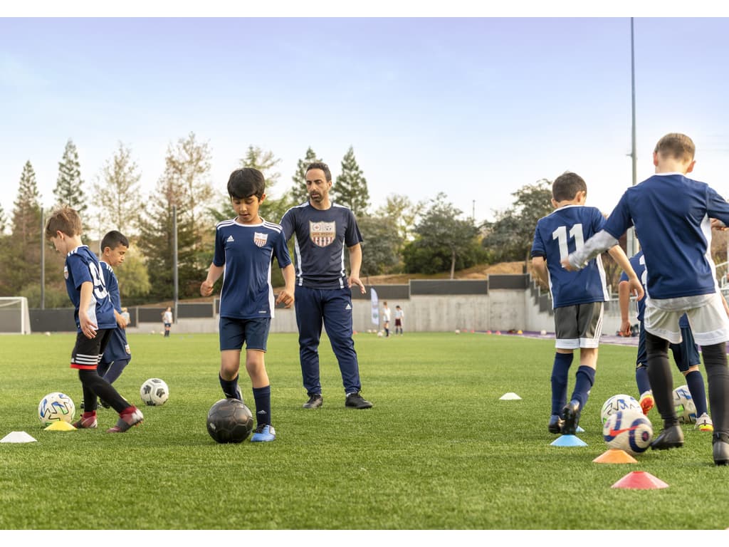 Como as escolas de futebol nos Estados Unidos colaboram para o desenvolvimento do esporte no mercado?
