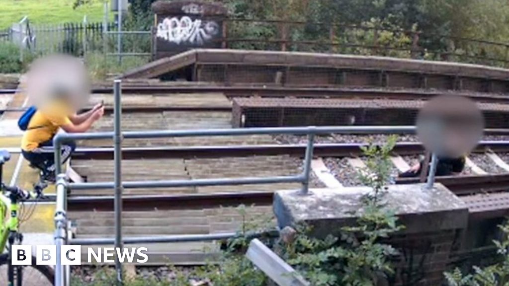 Watch: Couple take photo sat on rail line