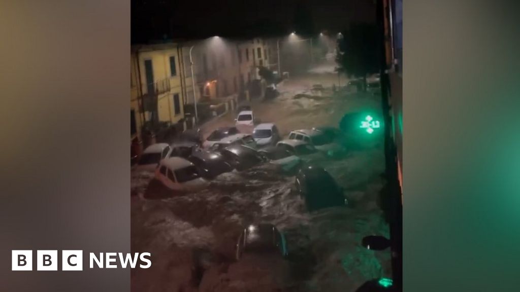 Moment cars swept away down street in Italy