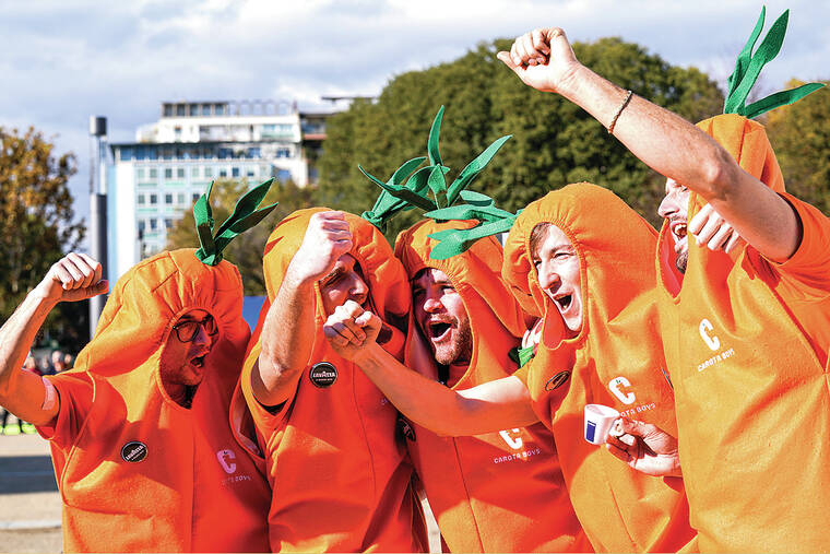 Jannik Sinner’s carrot-clad fans take root on the tennis tour in their orange-colored costumes