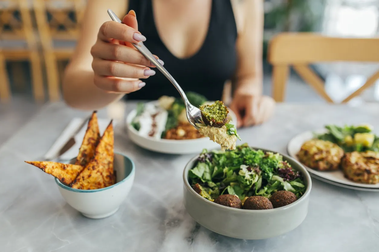 VegNews.FalafelWomanEating.Getty