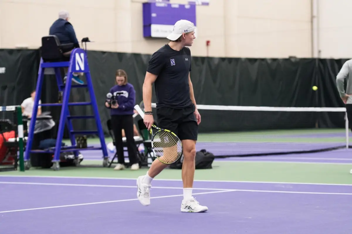 Tennis player Felix Nordby looks to the other side of the court holding a tennis racket.