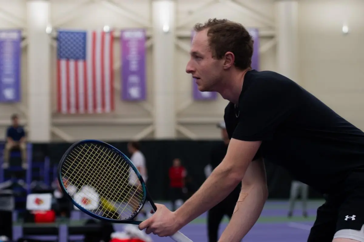 Tennis player Gleb Blekher holds out his tennis racket.