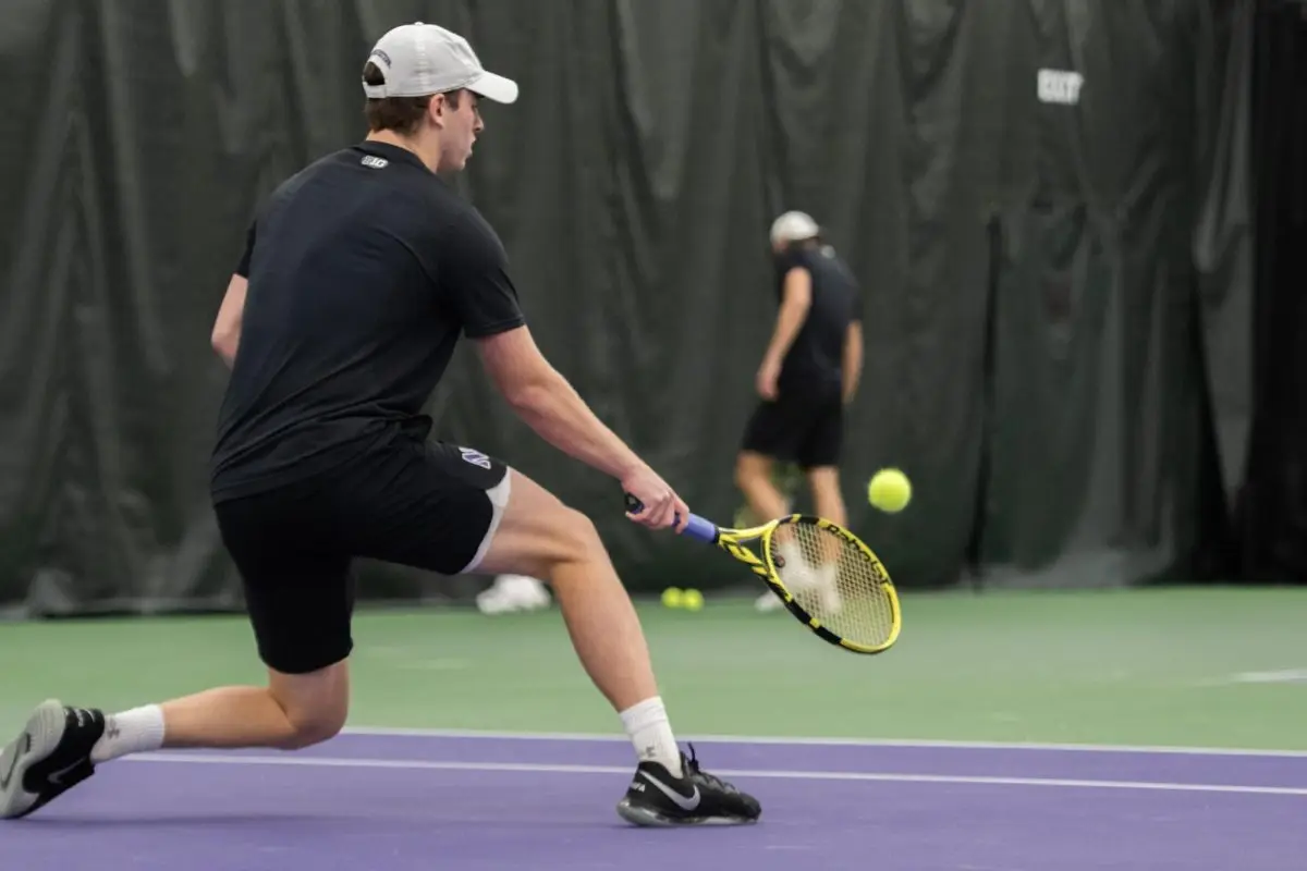 Tennis player Presley Thieneman kneels to hit the ball.