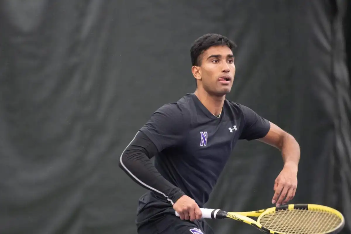 Tennis player Saiprakash Goli sticks out his tongue and prepares to hit the ball.