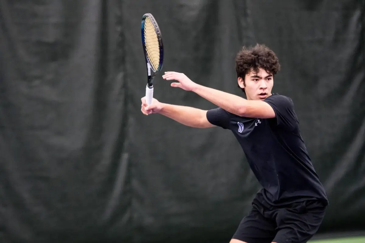 Northwestern tennis player Greyson Casey prepares to hit the ball.