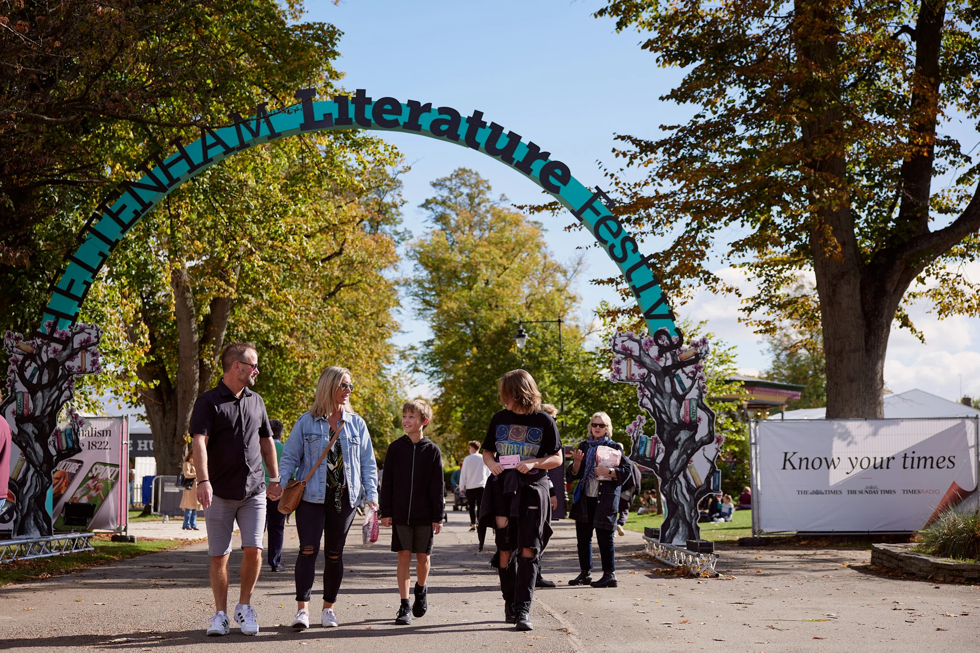 People walking under an archway reading 'Cheltenham Literature Festival'