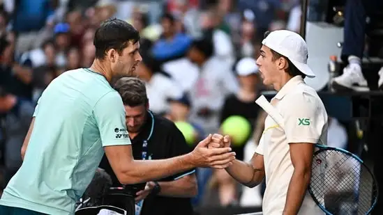 Poland's Hubert Hurkacz (L) shakes hands with France's Arthur Cazaux after the end of their men's singles match on day nine of the Australian Open tennis tournament in Melbourne on January 22(AFP)