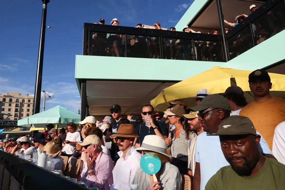 Fans watch France's Gael Monfils first round match from a bar overlooking court 6 at the Australian Open tennis championships at Melbourne Park, Melbourne, Australia, Monday, Jan. 15, 2024.There's a certainly a buzz around the bar that overlooks Court 6 and gives Australians Open fans a shady place to have a cool drink on a hot day, which is something of a national tradition. It's popular with fans but the music and constant movement adjacent to a Grand Slam tennis court is dividing opinion among players. (AP Photo/Asanka Brendon Ratnayake)