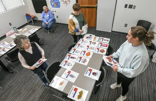 Sandy Hochstetler, left, talks with Health Educator Sarah Donnald, right, of the Clemson SNAP-ED program near examples of five food groups during the Cooking Matters! class, teaching nutrition and recipes in a class at Belton Library Tuesday, January 23, 2024. The cooking educational class shares ideas for mindful eating. The next class is February 27 at 2 p.m.