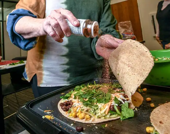 Carol Coddington adds taco seasoning to a black bean and vegetable quesadilla she made during a Clemson SNAP-ED program Cooking Matters! class, teaching nutrition and recipes in a class at Belton Library Tuesday, January 23, 2024. The next class is February 27 at 2 p.m.