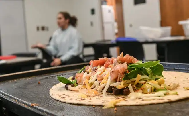 Anderson County Health Educator Sarah Donnald, left, talks while other participants keep making black bean and vegetable quesadillas during a Clemson SNAP-ED program Cooking Matters! class, teaching nutrition and recipes in a class at Belton Library Tuesday, January 23, 2024.