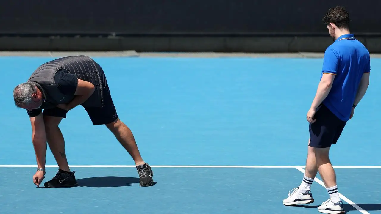 Australian Open officials inspect the surface of Court Three after a bubbling issue was flagged. (Photo by Phil Walter/Getty Images)